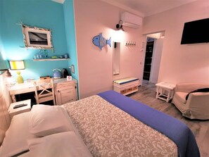 A bedroom with a bed, a desk, a chair, a mirror, a shelf with toiletries, and a TV. - AlCivico3 B&B (Civitanova Marche)