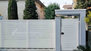 Una entrada con puerta y un camino pavimentado que conduce a un edificio.