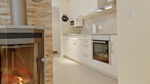 Uma cozinha moderna com fogão embutido, micro-ondas, forno e máquina de lavar louça.