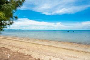 Perto da praia, espreguiçadeiras, guarda-sóis, toalhas de praia 