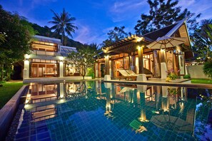 A modern resort with a large swimming pool, a covered outdoor area, and lush tropical surroundings. - The Emerald Beach Villa 4 (Koh Samui)