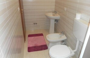 A small bathroom with a toilet, bidet, and sink. - Bed and Breakfast Ocurniciell (Naples)