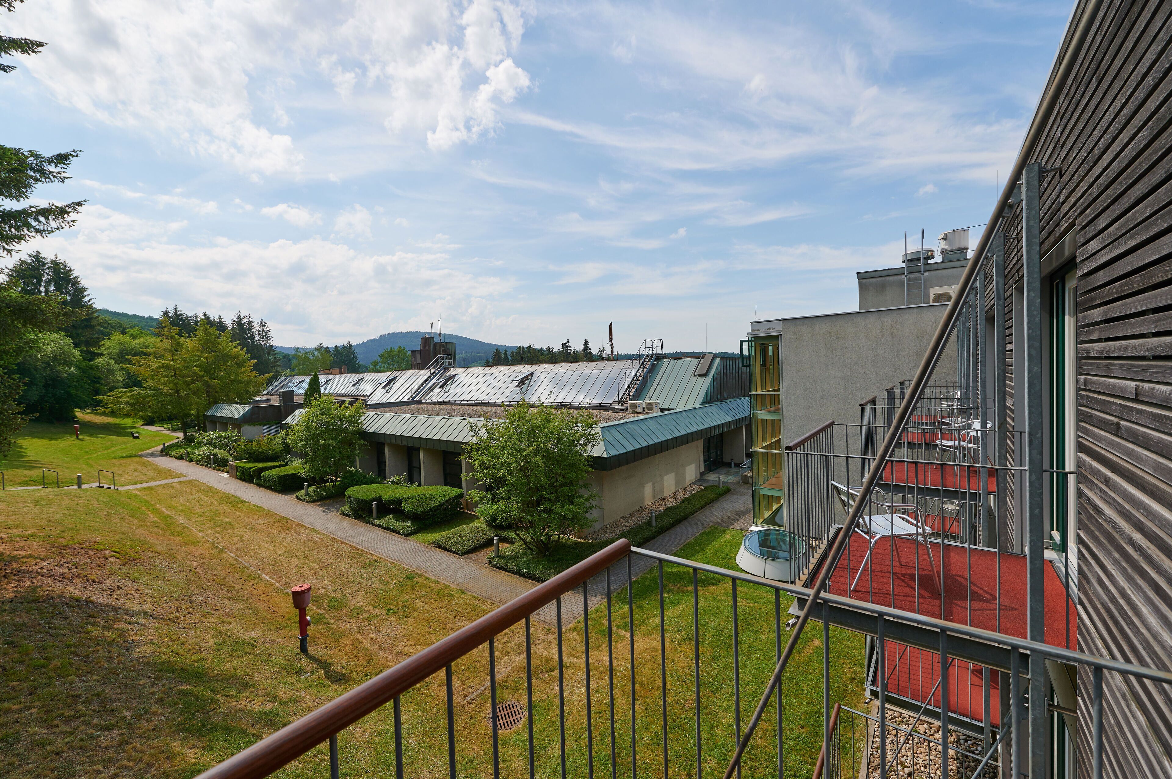 A modern building with a metal staircase and a red carpet leading to a door.