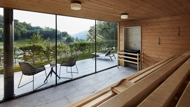 A modern spa with wooden interiors, large windows, and a view of a natural landscape.