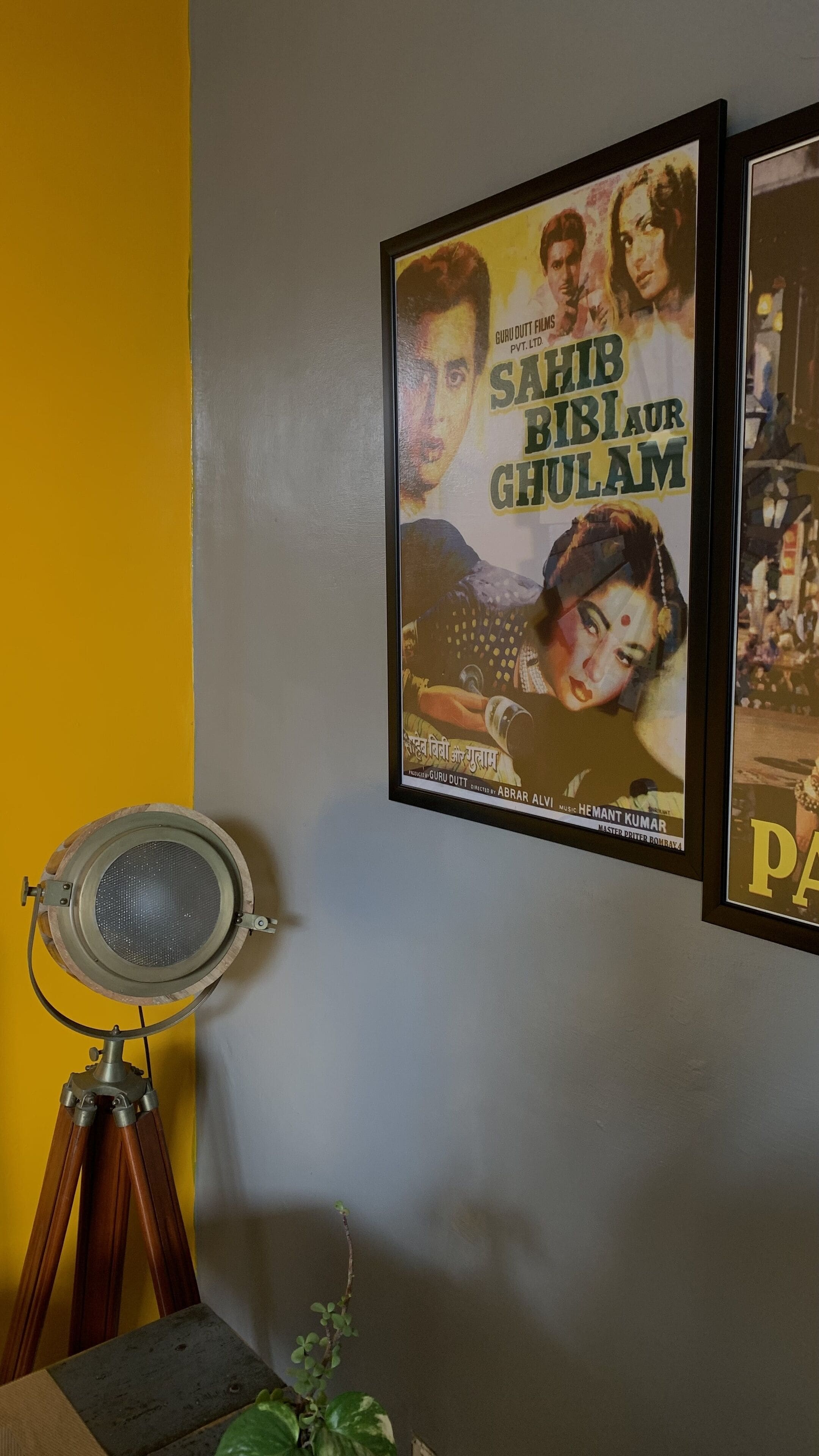 A wall with two framed movie posters and a vintage projector.