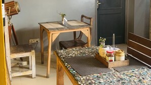 A room with a wooden table, two chairs, a telescope, and a door. - Bed & Chai Guest House (New Delhi)