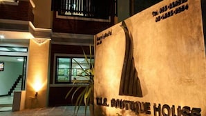 The exterior of TLA Boutique House with a stone facade, a staircase, and a large window. - TJR Boutique House (Chiang Mai)
