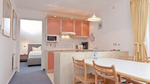 A compact kitchen with a dining area, a microwave, a toaster, and a sink.