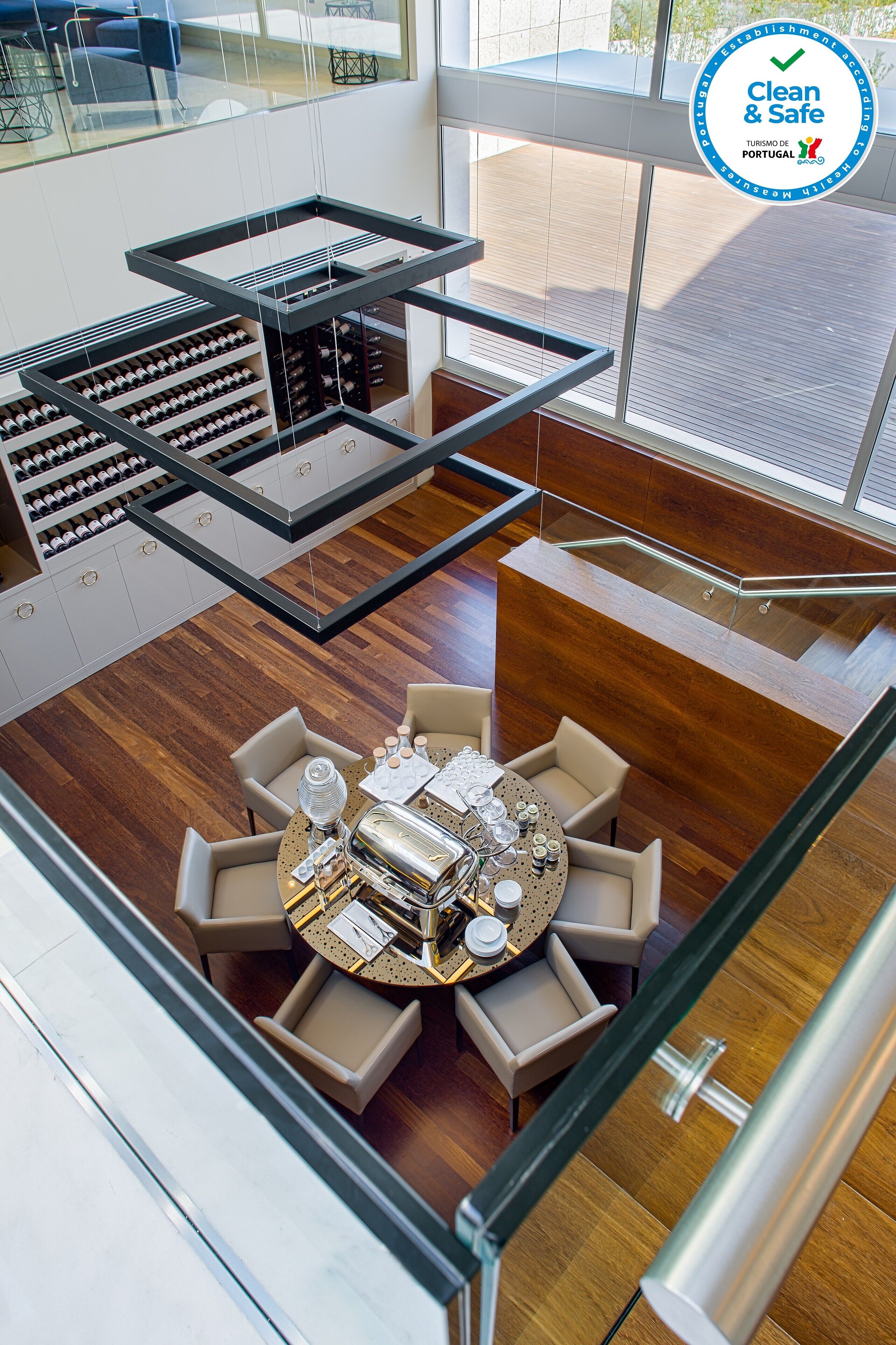 A modern interior with a dining area, wine racks, and a staircase.