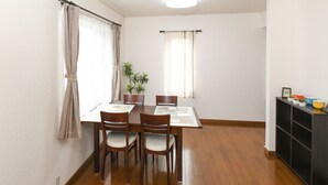 Un comedor con una mesa y sillas, una planta en maceta y un mueble con objetos encima.