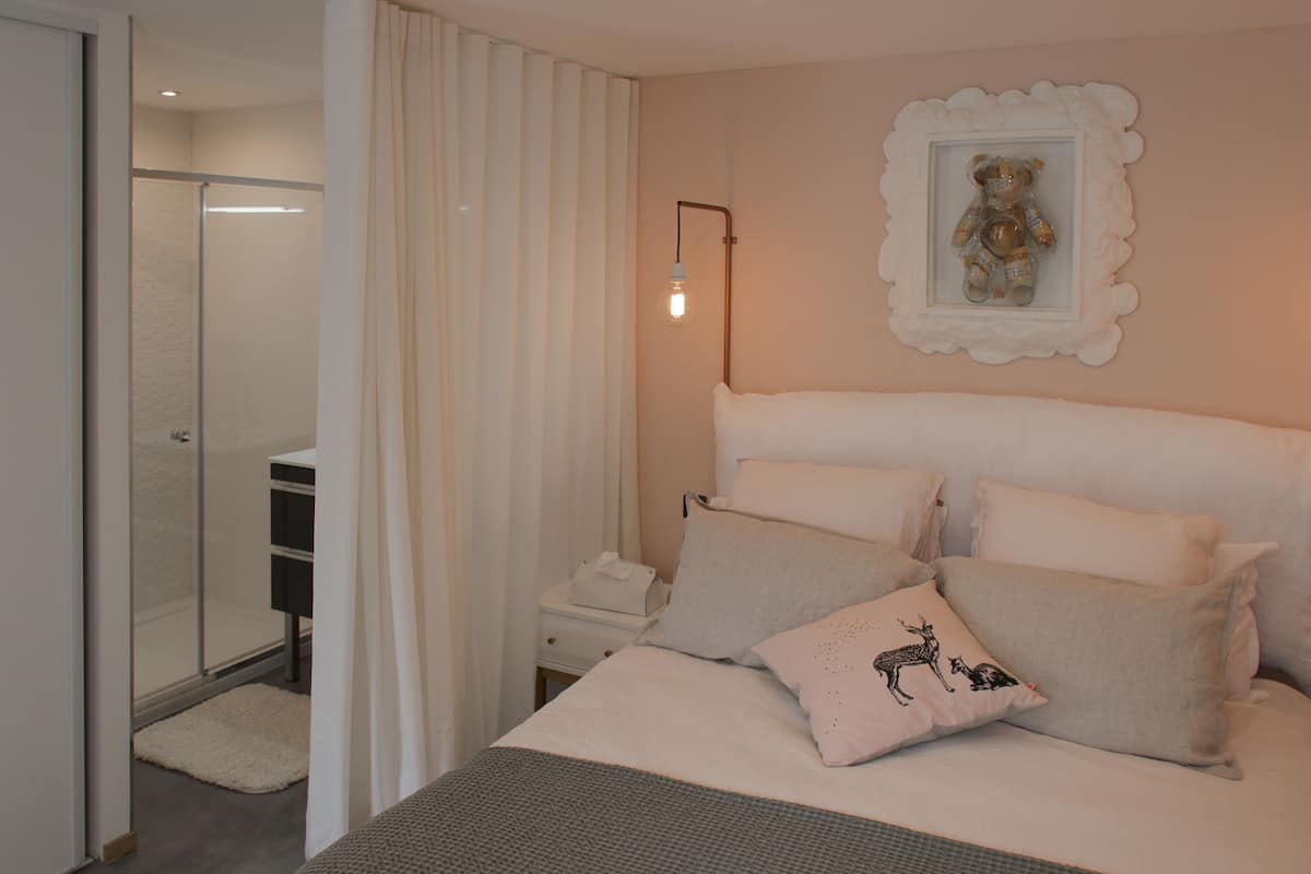 Ein Schlafzimmer mit Bett, Nachttisch und Spiegel.