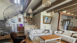 A spacious living area with a wooden staircase, a sofa set, and a coffee table. - Datcha Anastasia (Besse-et-Saint-Anastaise)