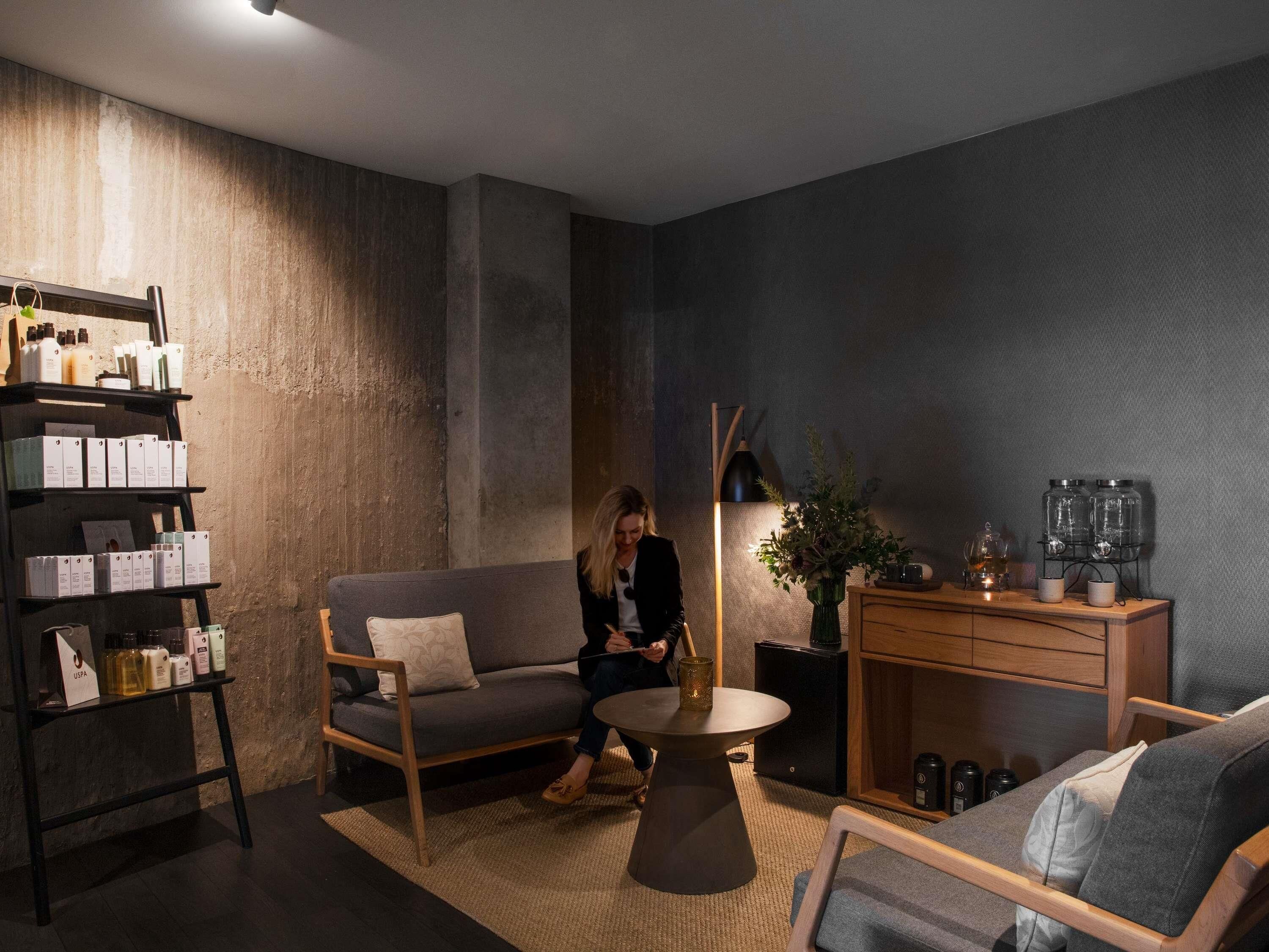 Ein modernes Wohnzimmer mit Sofa, Couchtisch und Bücherregal.