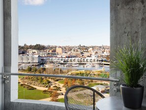 A balcony with a view of a marina, buildings, and a landscaped area. - Peppers Silo Launceston (Invermay)