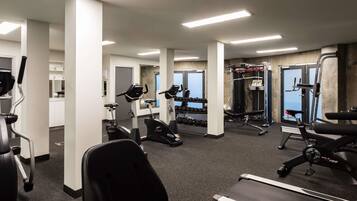 Une salle de sport équipée de tapis de course, de vélos elliptiques et de matériel de musculation.