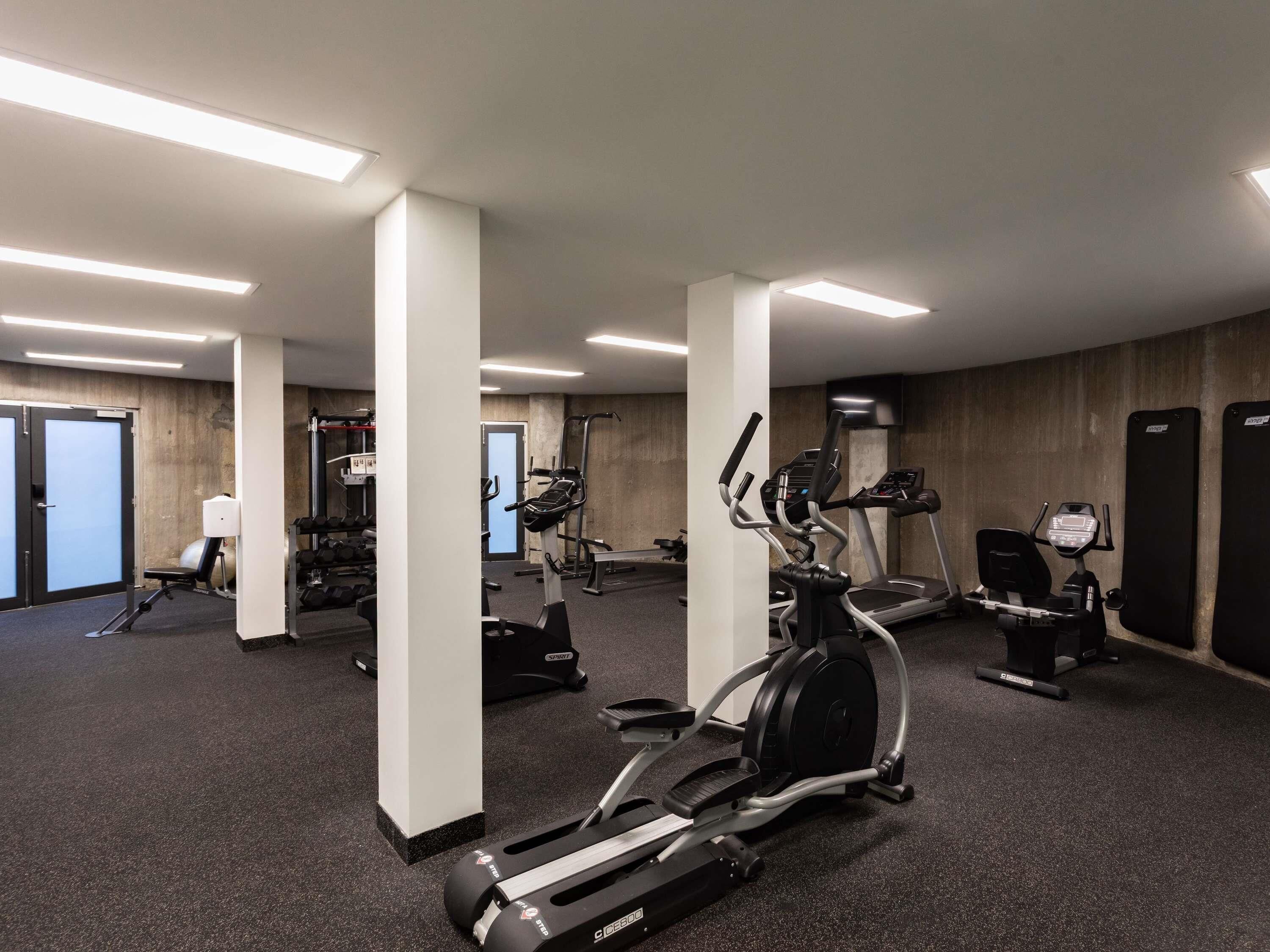 A gym with treadmills, elliptical machines, and weightlifting equipment.