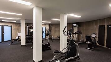 A gym with treadmills, elliptical machines, and weightlifting equipment.