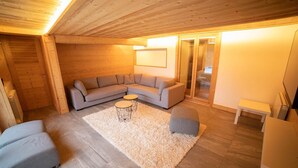 Una sala acogedora con un sofá seccional, una mesa de centro redonda y una alfombra mullida.