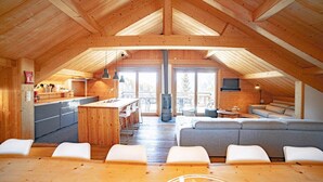 Una habitación estilo ático con cocina, comedor y zona de estar.