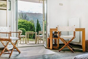 Ein Zimmer mit Blick auf eine grüne Landschaft, einem Tisch mit Stühlen und einem Projektor.