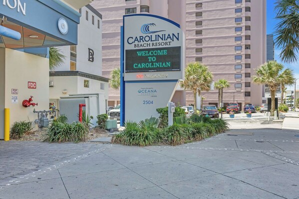 En skylt för Carolinian Beach Resort som välkomnar besökare, med en digital display och siffran 2504.