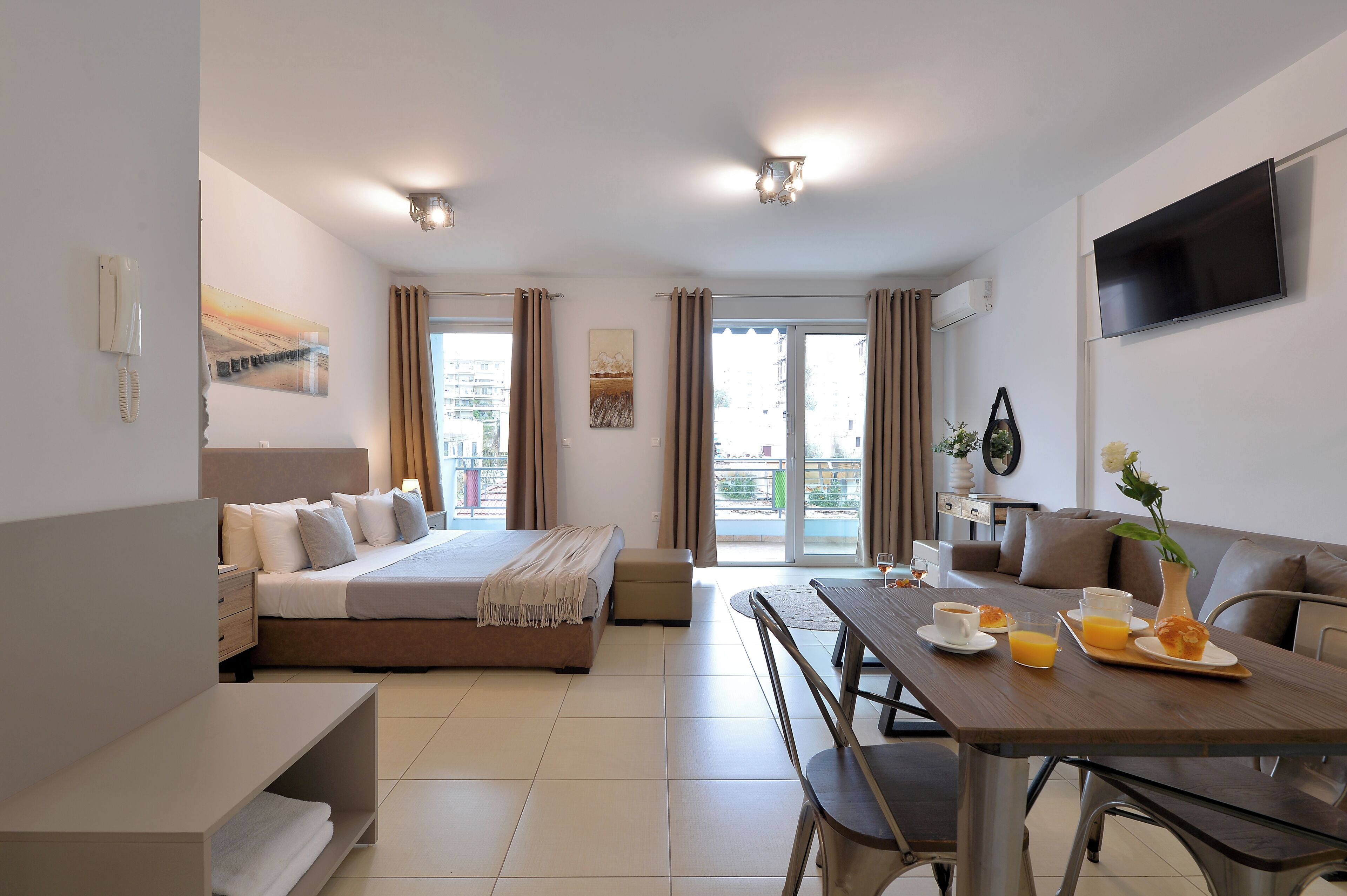 Une chambre d’hôtel moderne équipée d’un lit, d’un coin repas et d’une télévision.