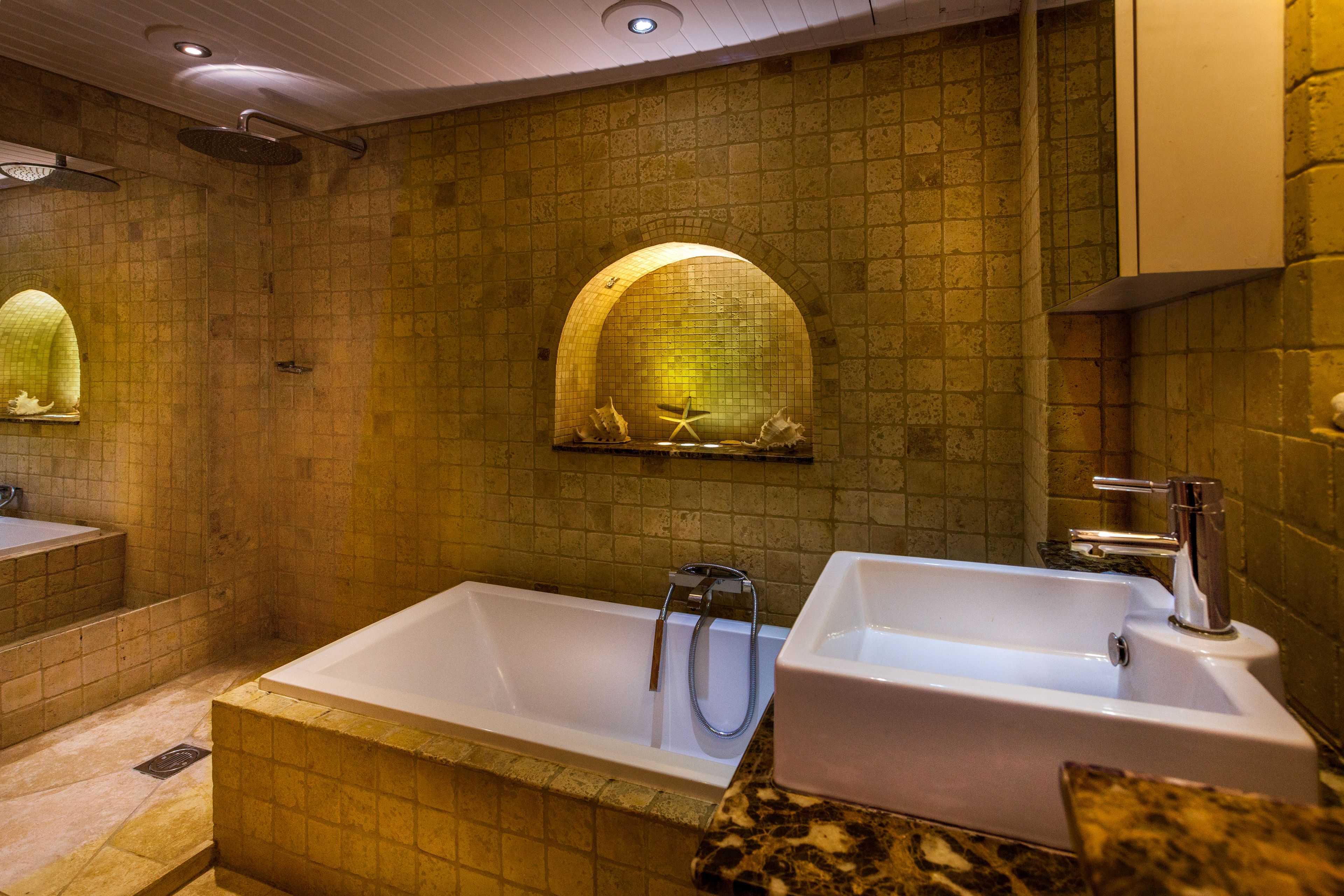 A bathroom with a large bathtub, two sinks, and a mirror.