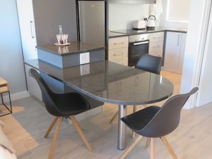 Enjoy meals in this well-equipped kitchen with a granite countertop, stainless steel appliances, and a dining table.
