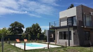 A modern two-story house with a swimming pool, a covered patio, and a fenced backyard. - Cabanas Bonarda (San Rafael)