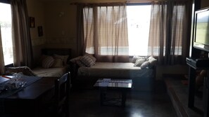 A room with two beds, a TV, and a table with papers. - Cabanas Bonarda (San Rafael)