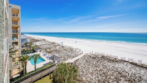 A beachfront hotel with a pool, beach access, and a clear view of the ocean.