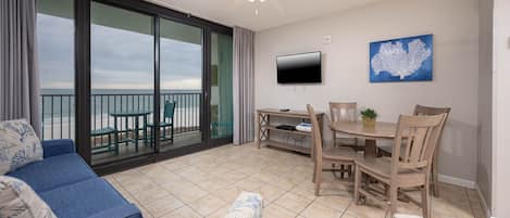 Relax in the inviting living area with comfortable seating and a mounted TV and enjoy views of the beach from the balcony