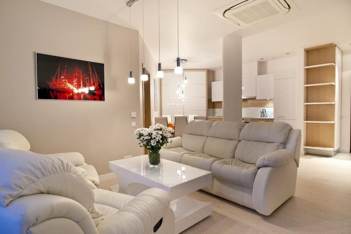 Un salon moderne avec un canapé, une table basse et un téléviseur fixé au mur.