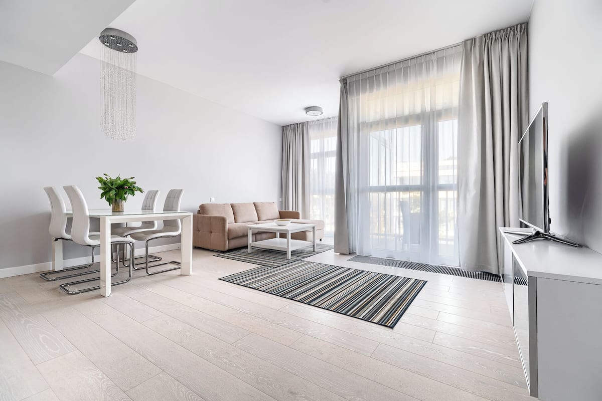 Un salon moderne avec un canapé, une table à manger et un téléviseur.
