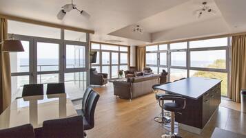 Apartamento ejecutivo, vistas al mar | Zona de estar | Una televisión