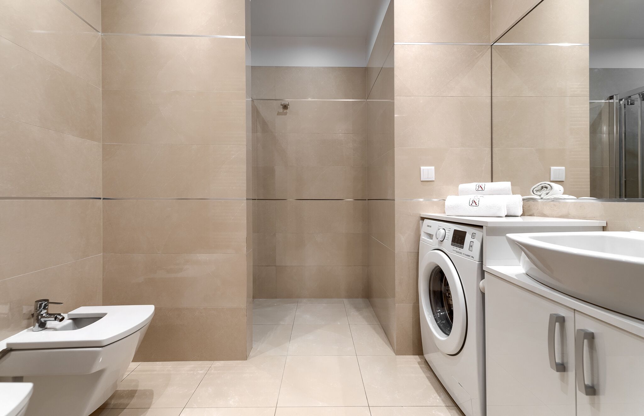 Ein modernes Badezimmer mit Toilette, Waschmaschine und Waschbecken.