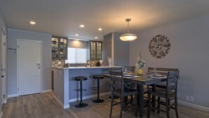 A modern kitchen with a central island, bar stools, and a dining table with chairs. - Amazing 2Bd/2Ba Scottsdale Condo directly across street from Fashion Square  (Scottsdale)