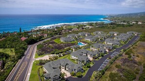 An aerial view of a coastal residential area with houses, a road, and a beach. - Aloha Condos, Na Hale O Keauhou, Townhome D-6, Ocean View, AC (Kailua Kona)