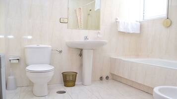 Un baño con inodoro, lavamanos y bañera.