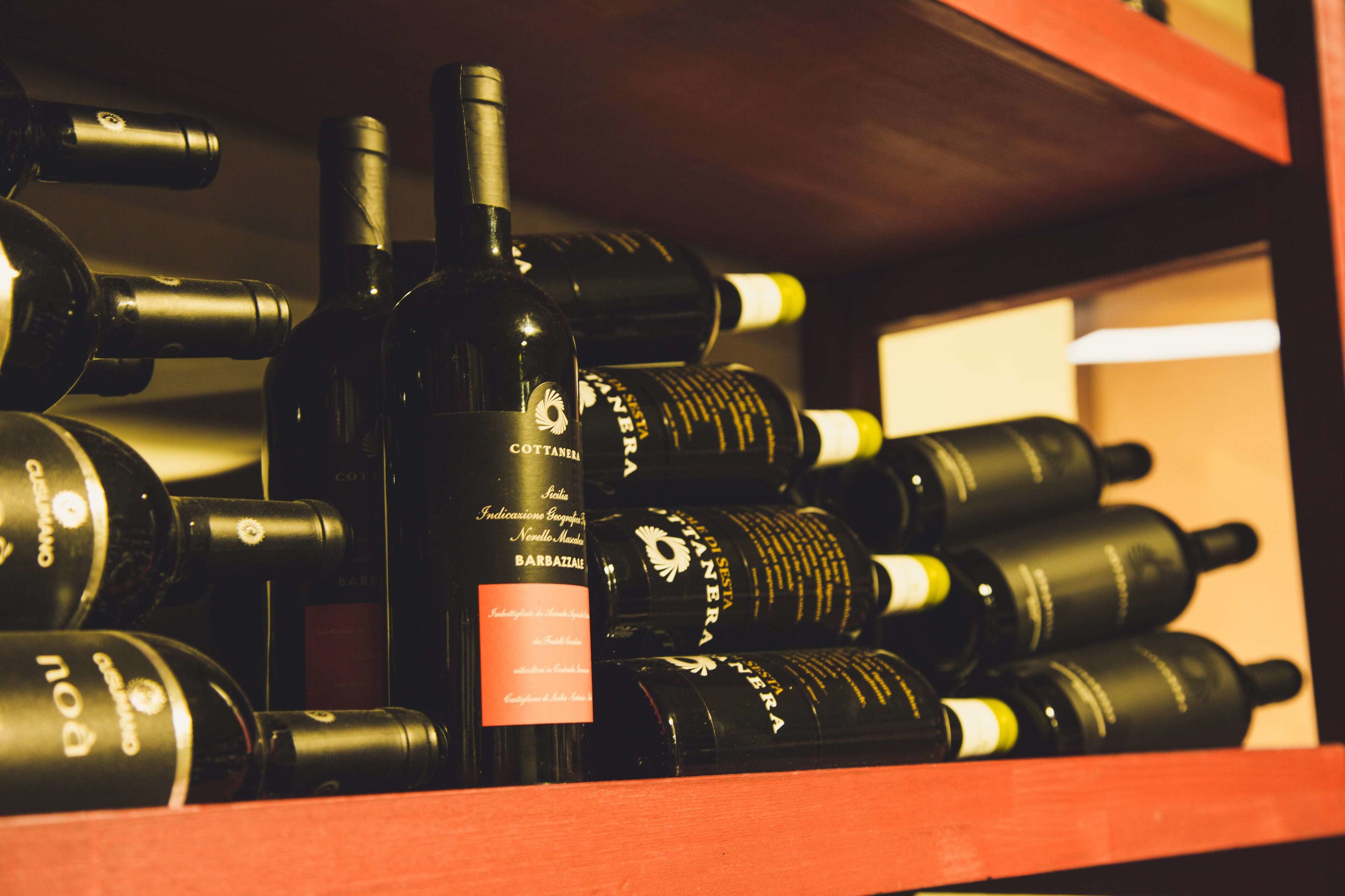 A shelf with multiple wine bottles.
