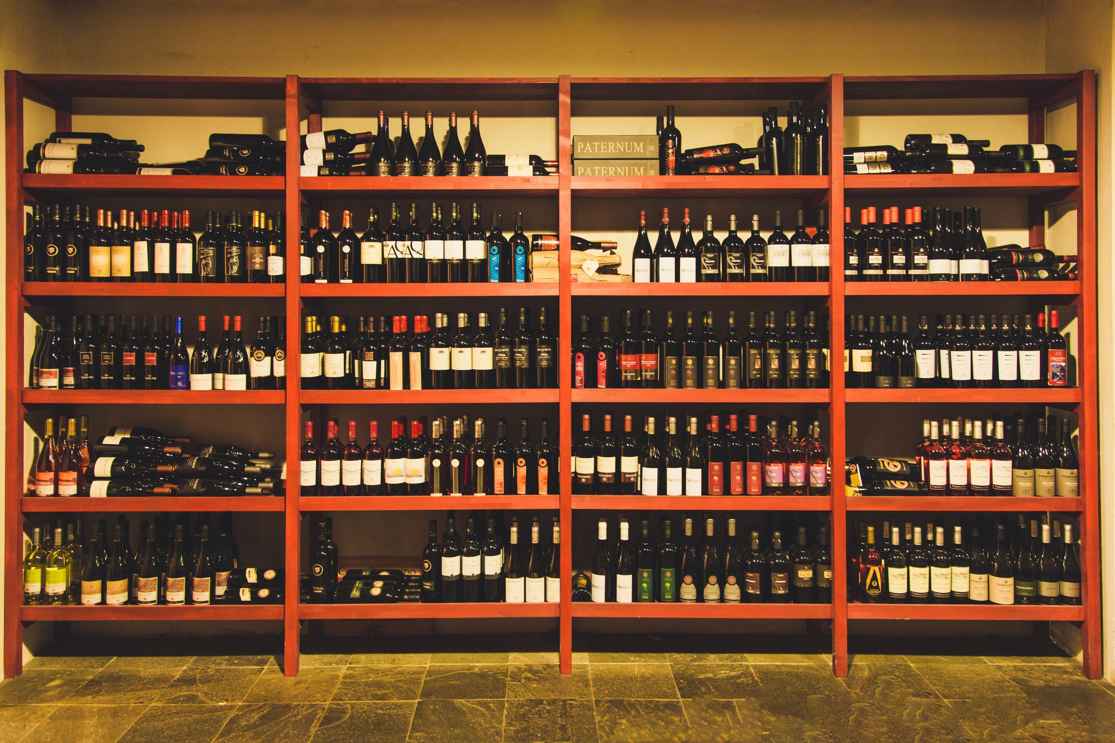 A wine cellar with multiple shelves stocked with various wine bottles.