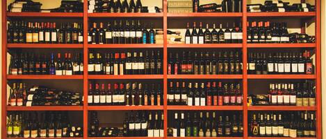 A wine cellar with multiple shelves stocked with various wine bottles.