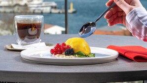 A table with a plate of food, a glass of drink, and a spoon. - Metropolitan Hotels Bosphorus (Istanbul)