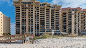 A high-rise hotel with multiple balconies, a beach view, and a sign indicating 'Phoenix 1'. - Stunning Gulf Views at Phoenix 1 1046 (Orange Beach)