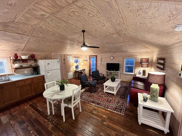 A cozy, wood-paneled interior with a dining area, kitchen, and seating space.