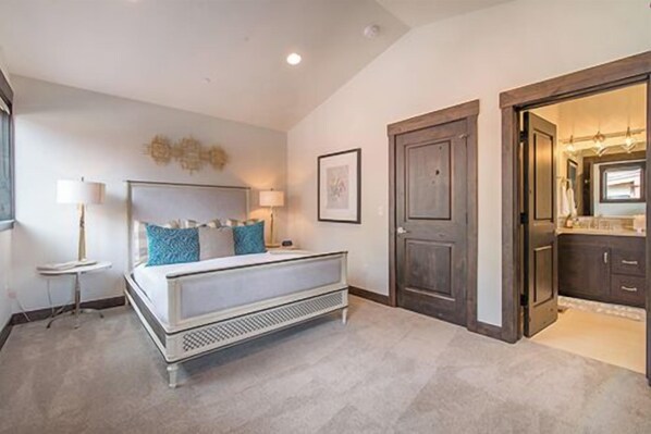 A bedroom with a bed, bedside lamps, a dresser, and a door leading to a bathroom. - Alpine Sierra at Schaffer's Mill, Club Amenities Ski & Golf, Lake Tahoe! (Truckee)