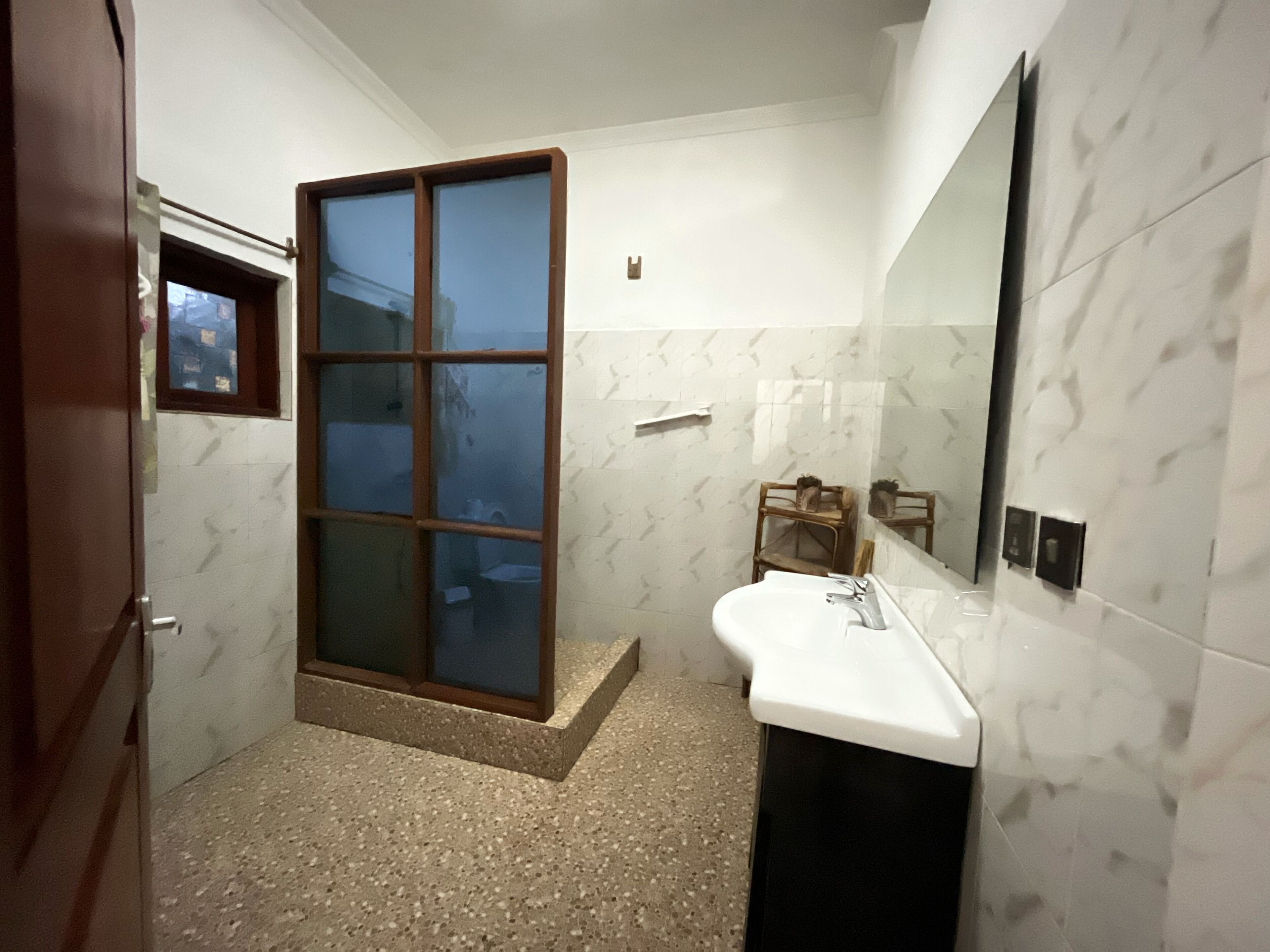 Une salle de bain avec une douche, un lavabo et un miroir.