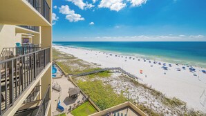 A beach view from a hotel balcony with a pool and beach chairs. - *TOP GUEST CHOICE* Premium Two Bedroom @ Phoenix II (Orange Beach)