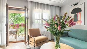 Un salon moderne avec un canapé, un fauteuil, une table basse et un vase rempli de fleurs.