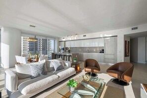 A modern living room with a sofa, coffee table, and a brown leather chair. - Infinite Ocean Luxury Three Bedroom Paradise (Hollywood)